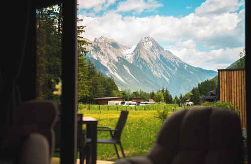 Pettneu am Arlberg House | Discover the Rosanna Cabin at Camping Arlberg, a stylish and sustainable accommodation surrounded by nature. Enjoy comfort and tranquility with stunning views of the Alps. The perfect place for a relaxing stay, all year round.